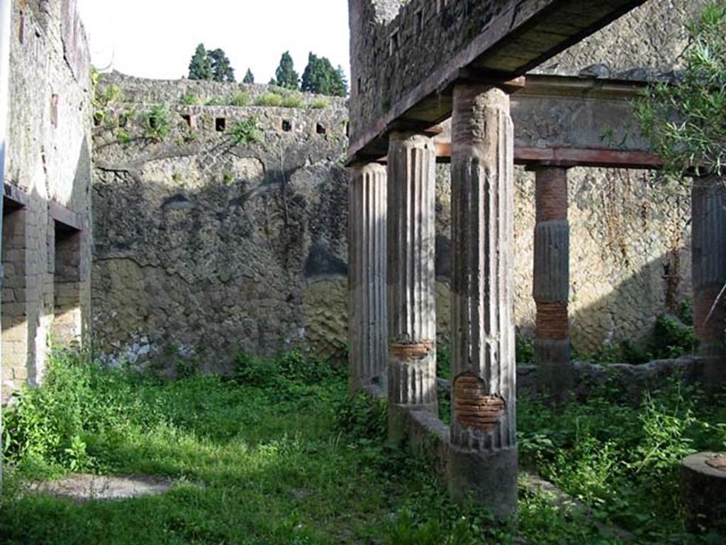 V.15, Herculaneum. May 2003. Looking east across north portico, with window and doorway to triclinium, on left.
Note the support holes for the upper floor beams. Photo courtesy of Nicolas Monteix.